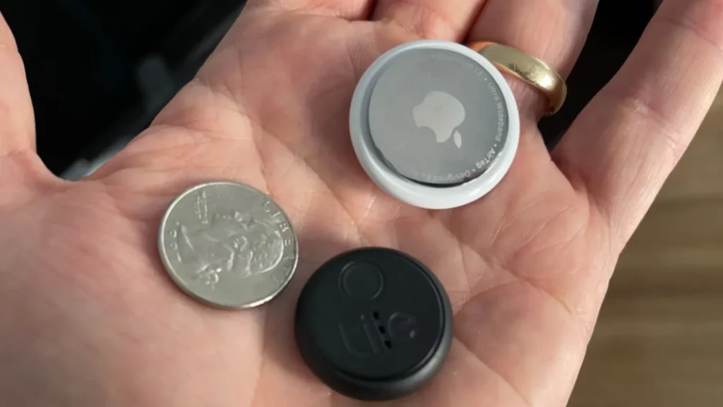 une main avec des trackers tiles et apple pour aider à retrouver ses affaires
